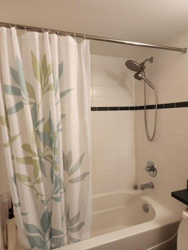 a bathroom with a shower curtain and a tub at Modern High-Rise 1 Bedroom Condo with water view near stadiums in Vancouver