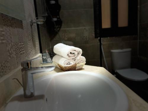 a bathroom with a sink with towels on a counter at Luxury Living - privado, Madinaty in Madinaty
