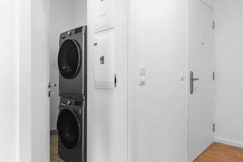 two washer and dryer in a room with white cabinets at BNB Panorama Bory Penthouse in Bratislava