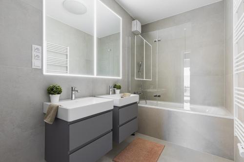 a bathroom with a white sink and a tub at BNB Panorama Bory Penthouse in Bratislava