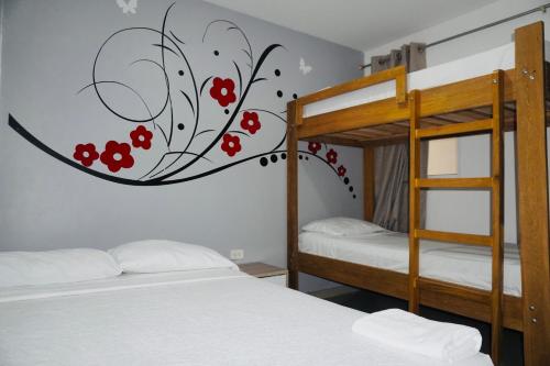 a bedroom with two bunk beds with red flowers on the wall at HOTEL BELLAMAR in Cartagena de Indias