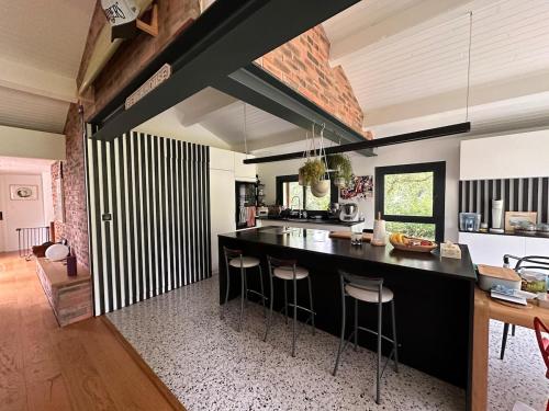 une cuisine avec un comptoir noir et un bar avec tabourets dans l'établissement Modern Hossegor Oasis, à Soorts-Hossegor