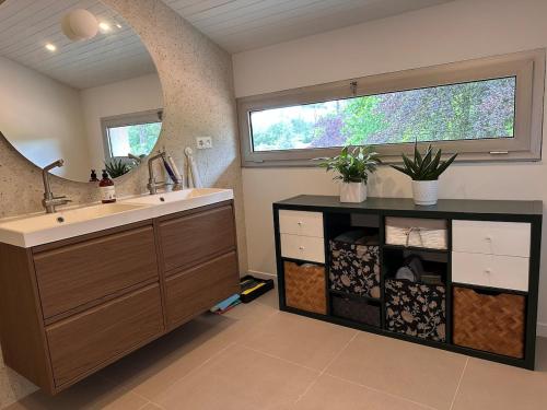 une salle de bain avec un lavabo et un grand miroir dans l'établissement Modern Hossegor Oasis, à Soorts-Hossegor