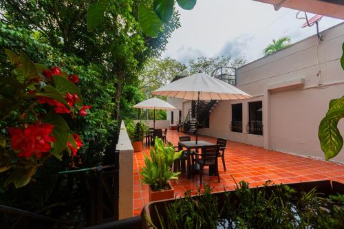 a patio with a table and chairs and umbrellas at Hotel Tropical San Jeronimo in San Jerónimo