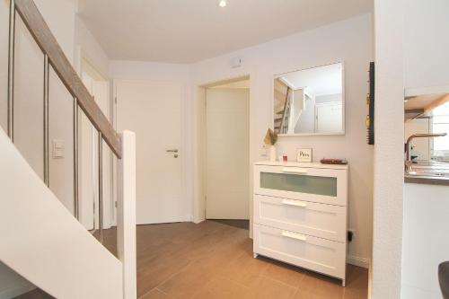 a white kitchen with a sink and a mirror at Hafenbrise in Greetsiel