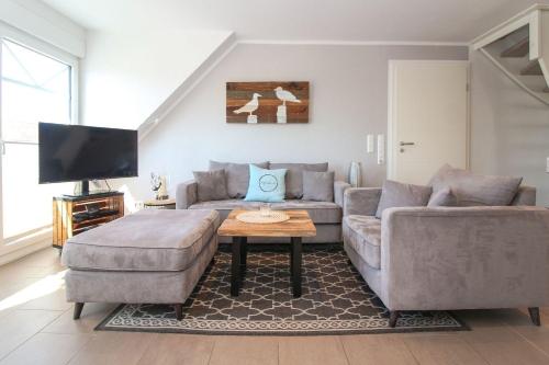 a living room with a couch and a table at Hafenbrise in Greetsiel