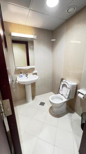 a bathroom with a toilet and a sink at Rest House Hostel in Abu Dhabi