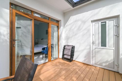 a room with a balcony with a door and a chair at Prawdziwa Jurata in Jurata