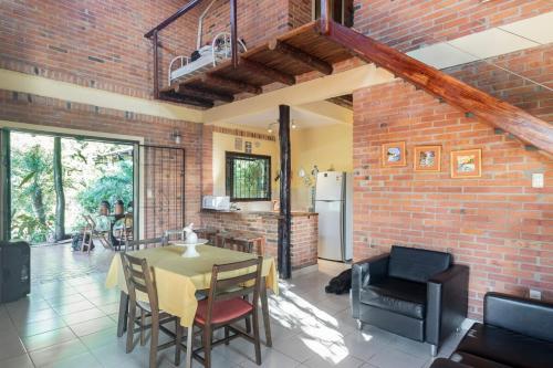 eine Küche und ein Esszimmer mit einem Tisch und einer Ziegelwand in der Unterkunft Casa Angi, con jardín y piscina en Sanber in San Bernardino