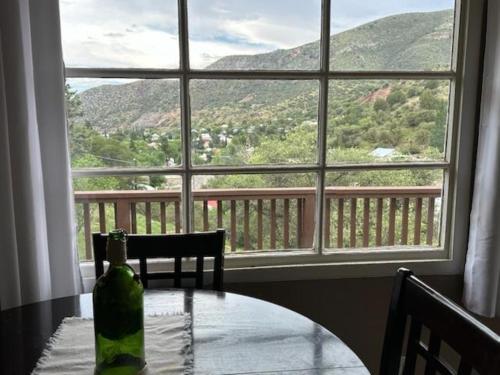 a bottle of wine sitting on a table in front of a window at Full House or Studio Suite with Breath Taking Views in Old Bisbee in Bisbee