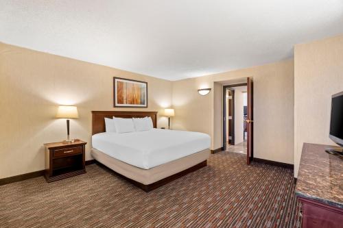 a hotel room with a bed and a flat screen tv at Prado Hotel by Choice Hotels in Ridgeland