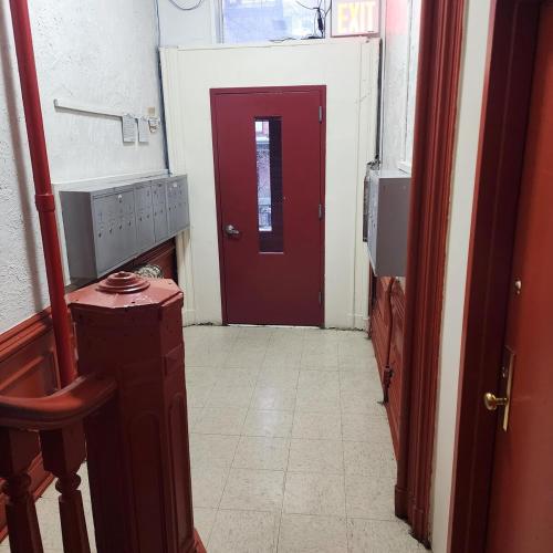 a hallway with a red door in a room at New York City GuestHouse in New York
