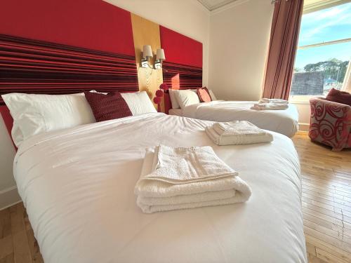 a hotel room with two beds with towels on them at The Clubhouse Nairn in Nairn
