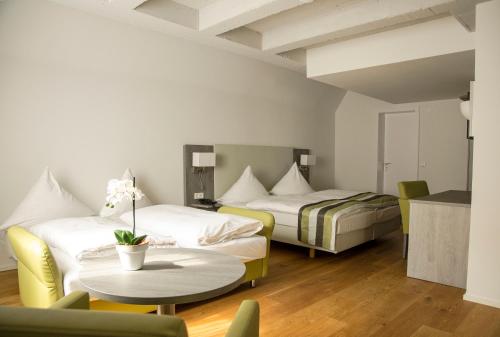 a hotel room with two beds and a table at Hotel am Schloss in Heidelberg