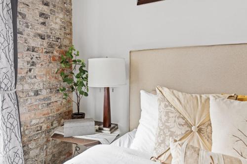 a bedroom with a bed and a brick wall at Downtown Free Parking Garage - 5 min walk OTR in Cincinnati