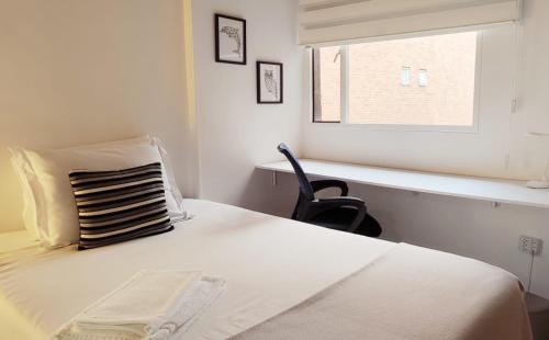 a bedroom with a bed with a chair and a window at Habitación 4 independiente con baño privado Unicentro in Bogotá