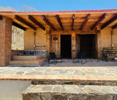 an outdoor patio with chairs and a fireplace at Casa Agave Huatulco in San Miguel
