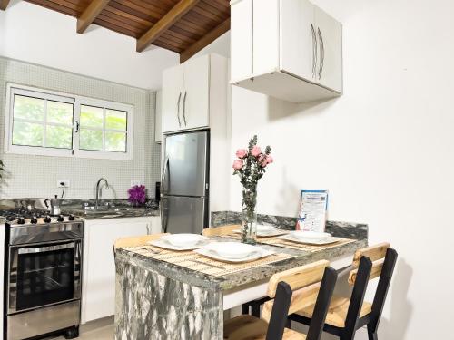 a kitchen with a table with chairs and a refrigerator at Blue Palm - Isla de Margarita in Paraguachi