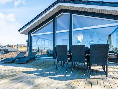 a dining table and chairs on a deck at 5 star holiday home in Løgstrup in Løgstrup