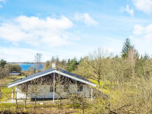a building with a roof on top of a field at 7 person holiday home in Skals-By Traum in Skals