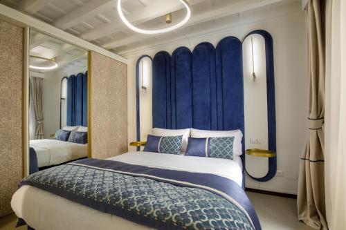 a bedroom with a large bed and blue curtains at Navona Sky Palace in Rome