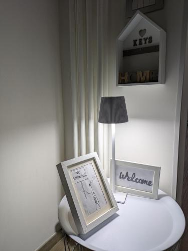 a table with a picture frame and a lamp on it at Il civico storico in Brindisi