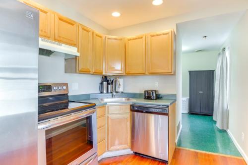 a kitchen with wooden cabinets and stainless steel appliances at 1 Block to Dtwn Seneca Falls Apartment with Yard! in Seneca Falls