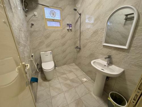 une salle de bains avec lavabo, toilettes et miroir dans l'établissement راكة سويت 1, à Khobar
