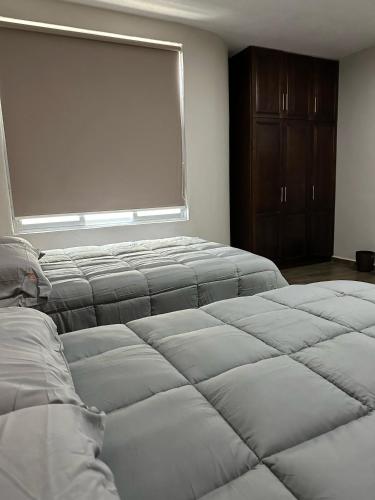 two beds in a room with a window at MR Hotel in San Pedro Jácuaro