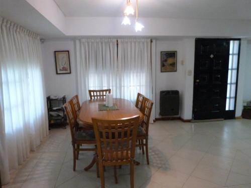 a dining room with a wooden table and chairs at Calma y Paz in Pueblo Esther