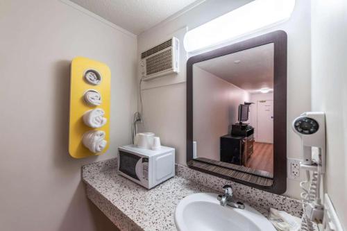 a bathroom with a sink and a mirror at Coastline Motel Kamloops in Kamloops