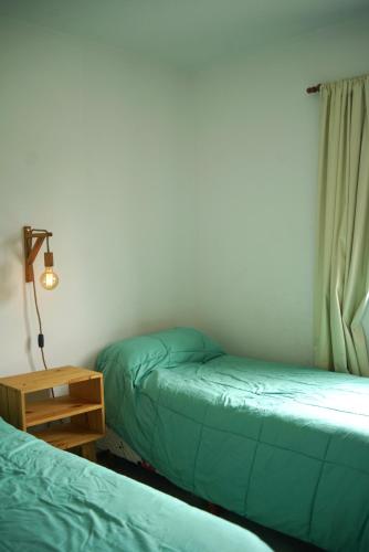 a room with two beds and a lamp and a table at Casa de campo Ranchos in Ranchos