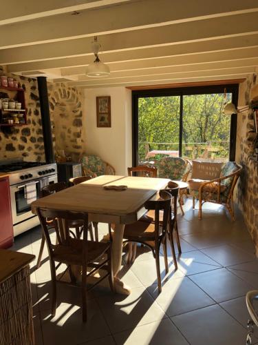 une salle à manger avec une table et des chaises en bois dans l'établissement Les pentes du chateau de Retourtour, à Lamastre