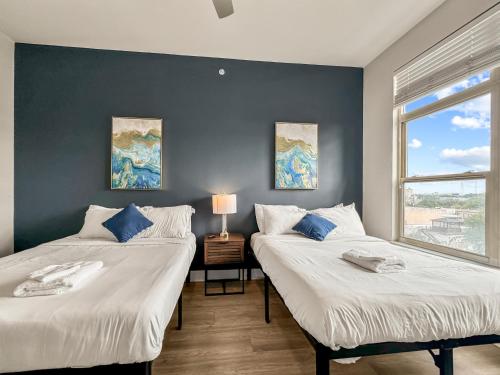 two beds sitting next to each other in a bedroom at Apartmint at Deep Ellum - Dallas in Dallas