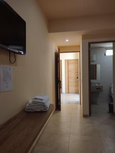 a room with a tv on the wall and a bathroom at Tortuga Real Huatulco in Santa Cruz Huatulco
