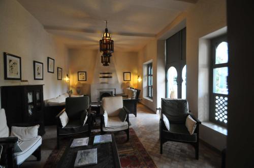 a living room with chairs and a couch and a fireplace at Palais Oumensour in Taroudant