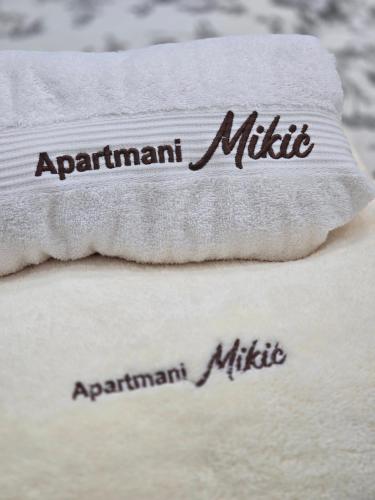 two towels with the words apartmentmitemite written on them at Apartmani Mikić in Bosanski Šamac