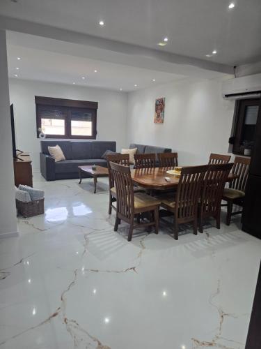 a living room with a table and chairs and a couch at Apartmani Mikić in Bosanski Šamac