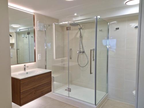 a bathroom with a shower and a sink at Evian villa with Lake Geneva views in 1960 mid-century modern style in Neuvecelle