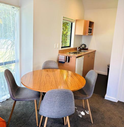a kitchen with a wooden table and chairs in a room at Bush Inn Court Motel in Christchurch