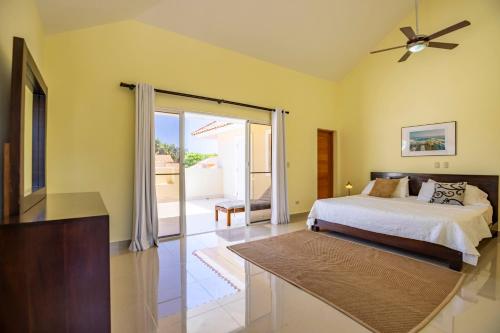 a bedroom with a bed and a sliding glass door at Pro Cab Paradise Condos Cabarete in Cabarete