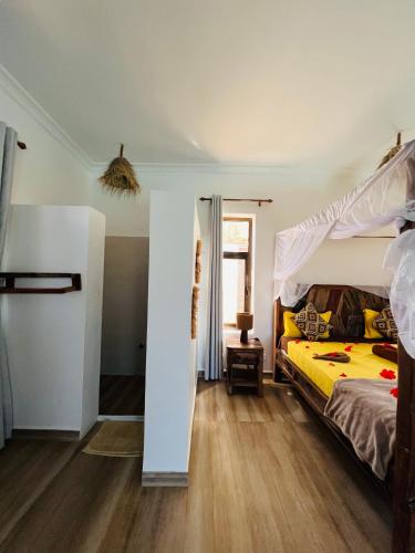 a bedroom with a bed with a yellow comforter at Z-Love Zanzibar in Kiwengwa