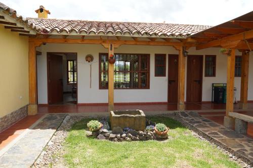 a house with a garden in front of it at Hotel Campestre Casa La María in Firavitoba