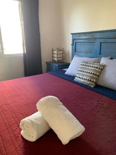 a white towel laying on top of a bed at Bungalows La Perla in San Francisco