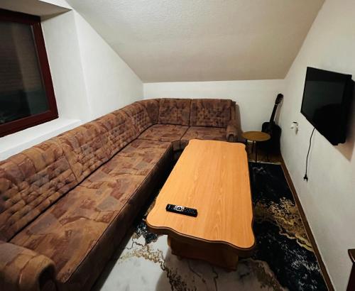 a couch with a wooden table in a living room at Rooms Cobras II in Jajce