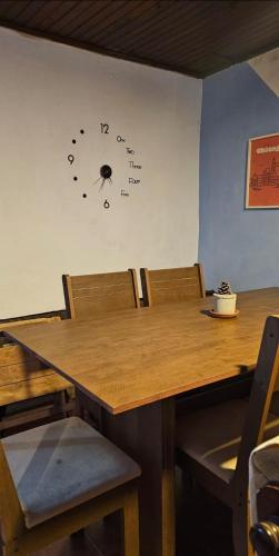 a wooden table with chairs and a clock on the wall at Hospedaje Nerea in Salto