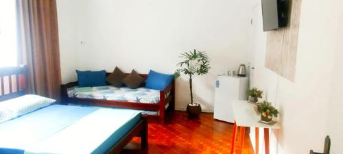 グアルジャにあるQuarto Privativo Praia das Pitangueirasのソファとテーブルのあるリビングルーム