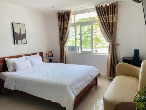 a bedroom with a bed and a window and a chair at KHÁCH SẠN ROMO in Quang Ngai