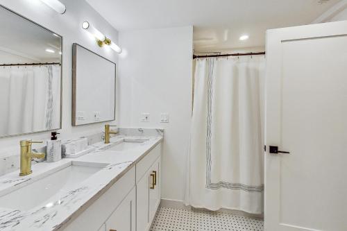 a white bathroom with two sinks and a mirror at Luxurious Lincoln Park Home with Gourmet Kitchen in Chicago
