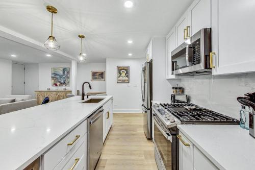 a kitchen with white cabinets and a stove top oven at Luxurious Lincoln Park Home with Gourmet Kitchen in Chicago